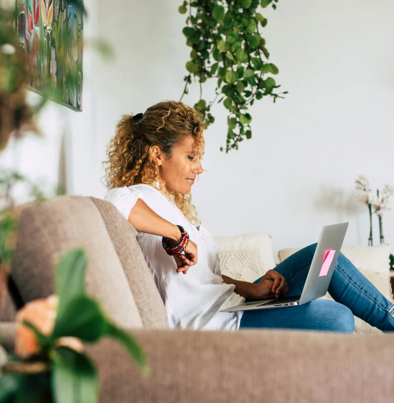 Une femme dans un fauteuil faisant des recherches sur un ordinateur portable.